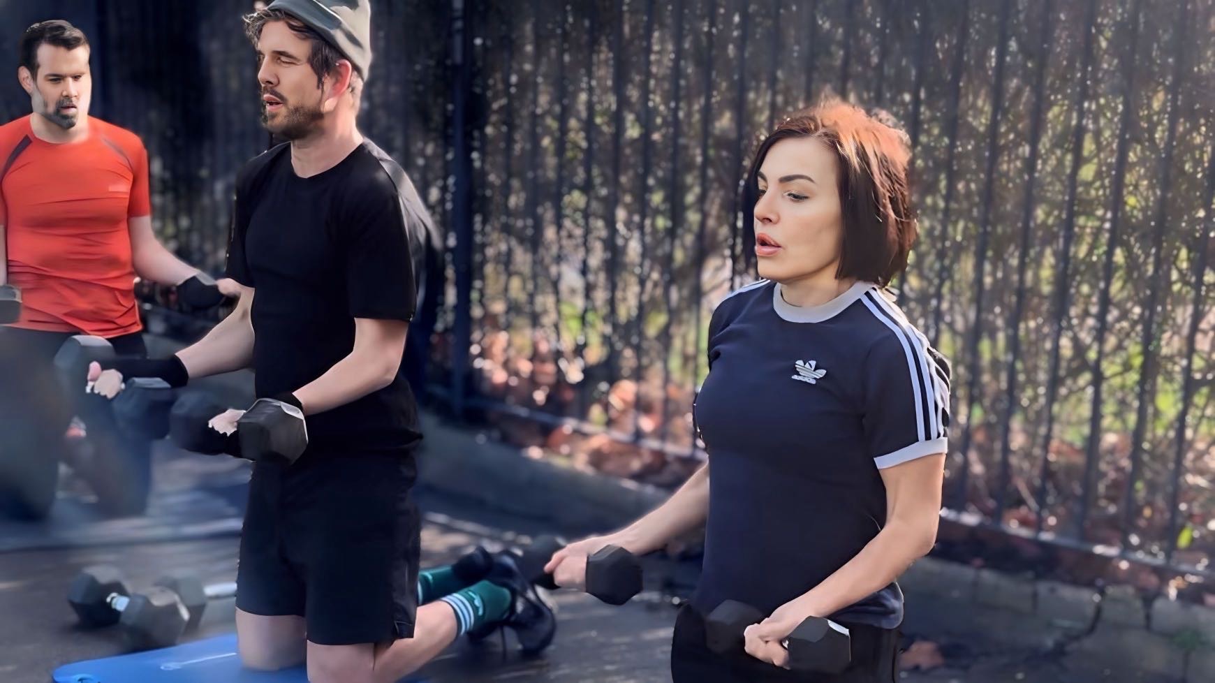 Fitness enthusiasts doing a bicep exercise using training equipment at eastham central park