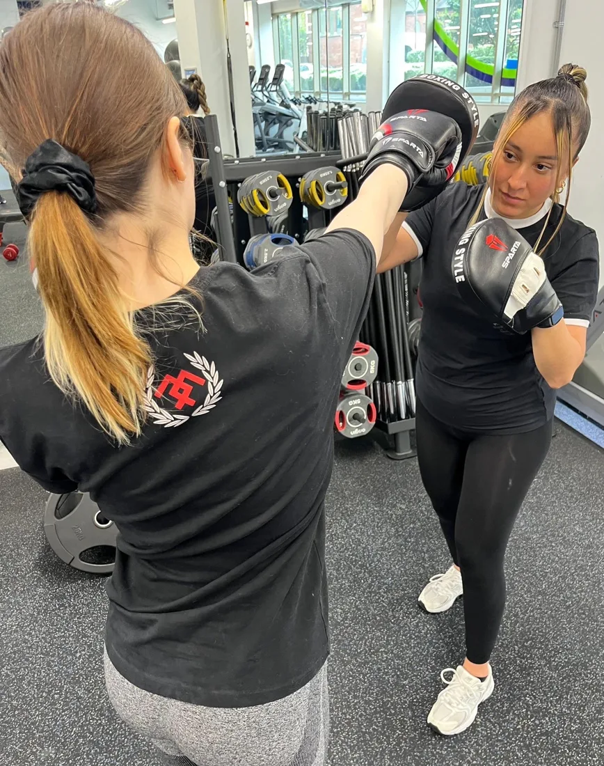 Boxing padwork with a female personal trainer for clients in Bow